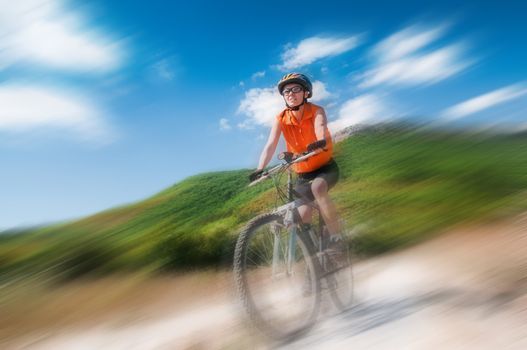 young female riding a mountain bike outdoor with blur background