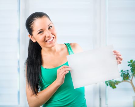 Portrait of happy young casual woman holding a blank signboard, horizontally