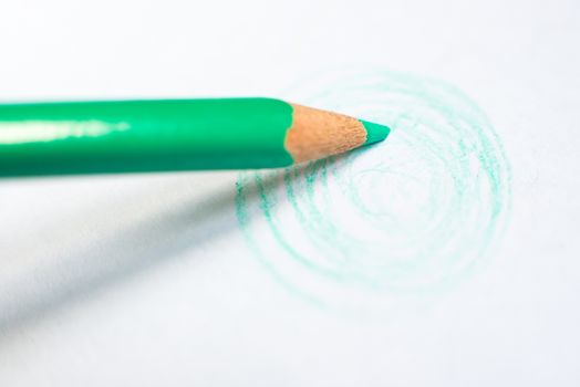 green pencil drawing rounds on white paper