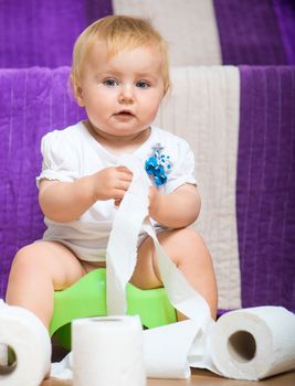 adorable baby on the potty with toilet paper