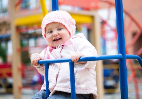 smiling little baby swinging at the park