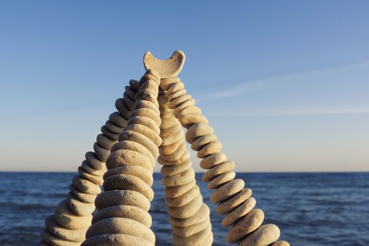 Pyramidal group of small pebbles in the balance on the seacoast