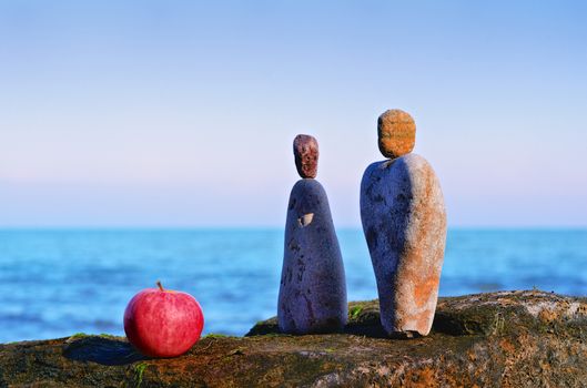 Apple and stones as symbol of man and woman