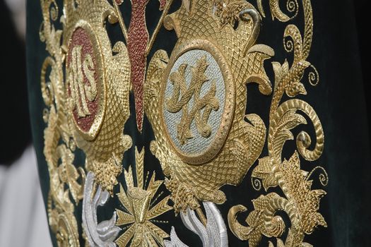 Embroidery thread of gold on green velvet with the acronym for Christ and Mary, Spain