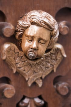 Cherub with suck on wood carving, concept ironic, holy week, Spain