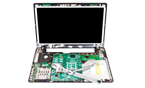 Laptop disassembled with two wrenches on it