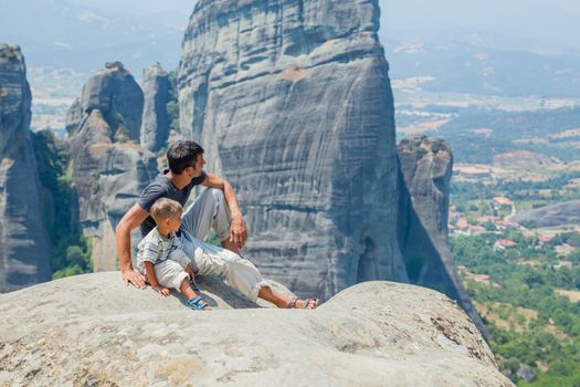 Father and son looking at the town of Kalambaka bird's eye view. Meteora, Greece.