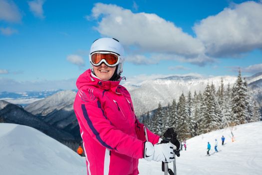 Portrait of young woman on skis in soft snow in the mountains