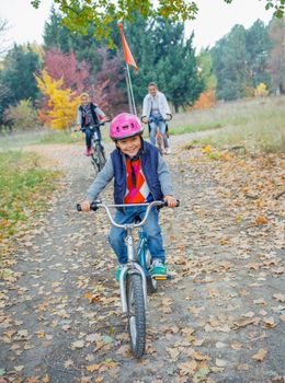 Cute little boy on bicycle in the autumn park.