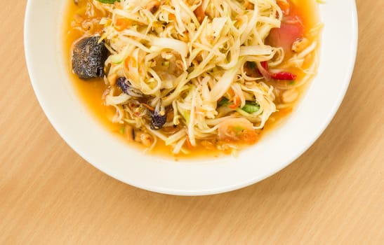 Spicy papaya salad with crab on wood table