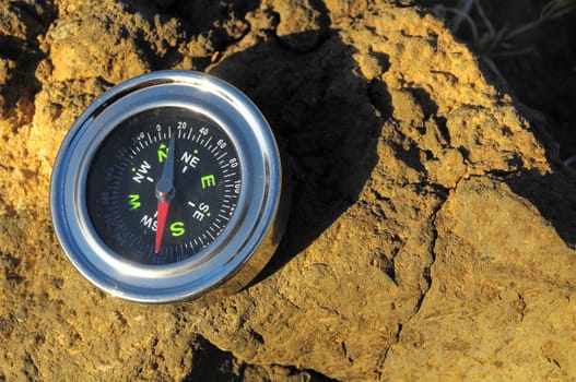 Orientation Concept Metal Compass on a Rock in the Desert