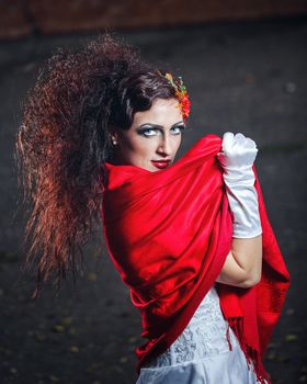 Attractive bride in a wedding dress with bright makeup, red shawl