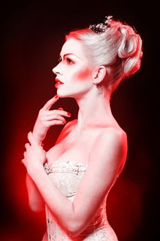 Red Queen with a crown and a corset, with make-up in studio shot