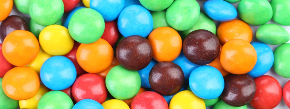 Backgroynd of chocolate balls in colorful glaze. Whole background