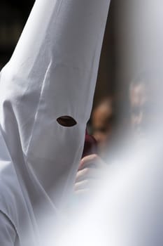 Detail penitent red holding a candle during Holy Week, Spain