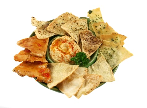 Colorful and textured baked pita bread crisps with hommus dip.