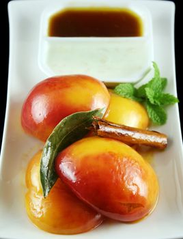Poached nectarines with a honey syrup glaze and nut yogurt and a cinnamon stick.