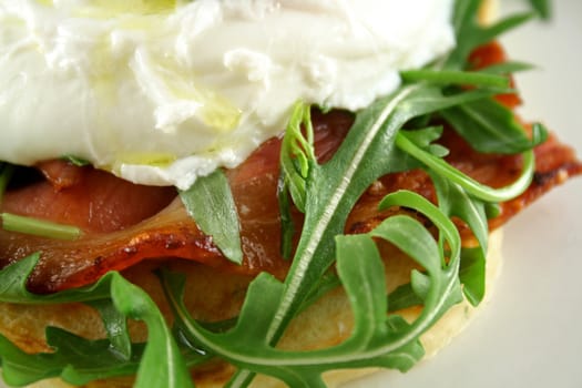 Poached egg with pesto, bacon, greens and sun dried tomatoes.