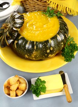 Delcious pumpkin soup in a pumkin with croutons and butter.