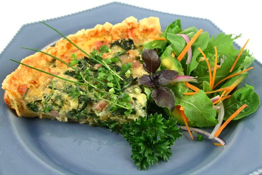 Sliced spinach and bacon quiche with a green salad.