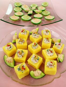 Finger food of tuna filled polentas and cucumber rounds ready to serve.