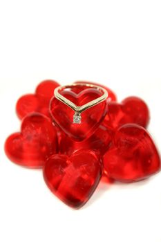 Engagement ring set on a mound of glass hearts.