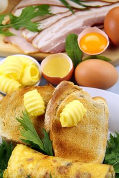 Toast, bacon, eggs with butter ready to be cooked for breakfast.
