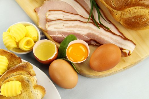 Bread, bacon, eggs with toast ready to be cooked for breakfast.