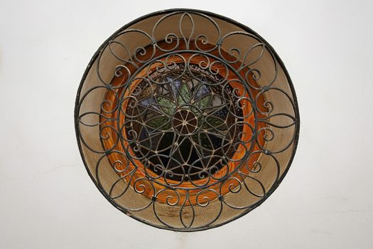 Rounded Window with wooden frame and stained glass on a white wall, Ubeda, Jaen province, Andalucia, Spain