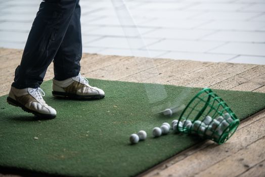 Man hits range balls at the practice area of a golf course