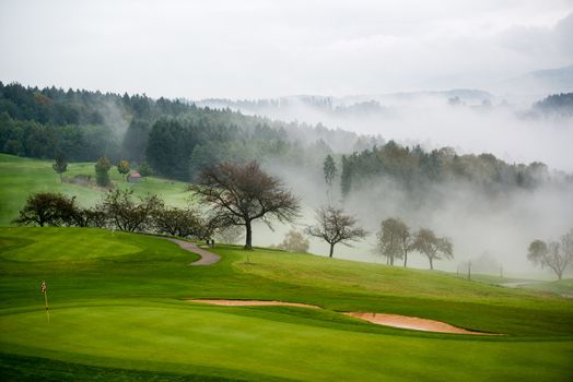 Autumn on the golf course in the mist at sunrise