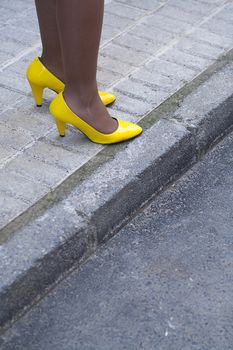 Beautiful legs of young girl in tights and yellow shoes