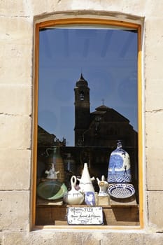 Reflection in a window of a store of the Church of el Salvador, Ubeda, Jaen province, Andalusia, Spain