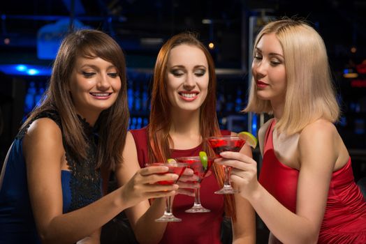 three girls raised their glasses in a nightclub, have fun with friends