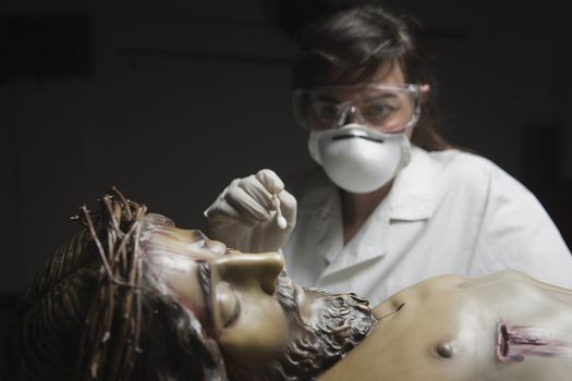 conservative restoring an image of Christ crucified on wood, Andalusia, Spain