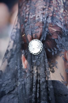 Detail of mantilla and touched embroidered black with silver snap during a procession of holy week, Andalusia, Spain