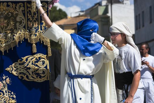 Nazarene that goes with the hand on the manigueta the throne in a procession of holy week. Not wearing capirote, and the mask falls loose by the head, back, like the penitents, Spain