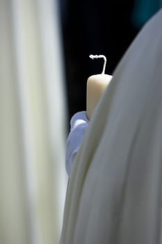 Detail penitent white holding a candle during Holy Week, Andalusia, Spain