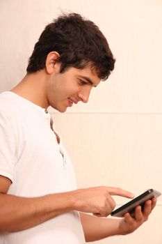 A young, latin man playing with a Tablet PC, face in focus
