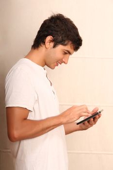 A young, latin man playing with a Tablet PC, face in focus

