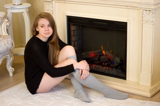 The beautiful girl  a burning fireplace for new year