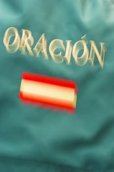 Optical on green canvas of the Spanish flag and the word prayer