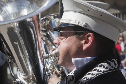 Musician blowing a wind instrument or tuba in a procession of holy week, this band wears the uniform of Captain of Squad of the Royal escort of Alfonso XIII, Linares, Jaen province,  Spain