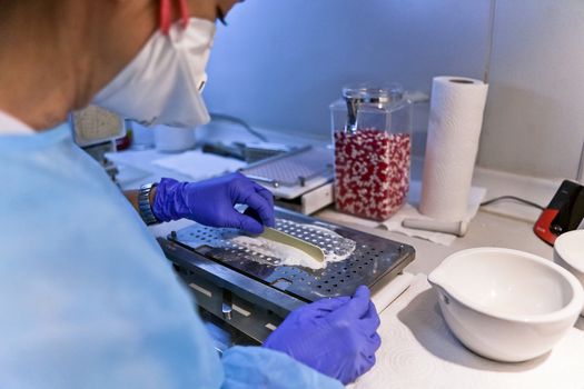 Packing white and red capsules in a sorting machine in a pharmaceutical laboratory, Spain