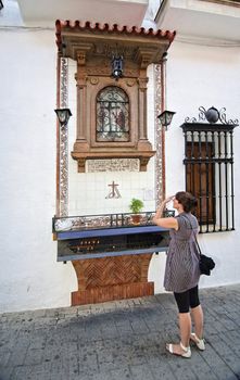 Woman praying before the altar of the Christ of Providence, Andujar, Jaen province, Andalusia, Spain