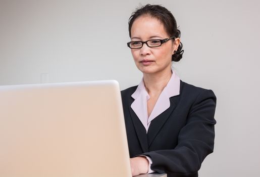 Professional woman in business suit working and typing on laptop