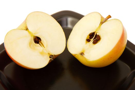 two halves of an apple on a black plate