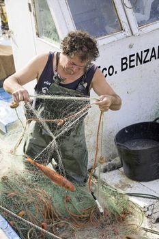 Fisherman removing fish nets in the port of estepona, Malaga Province, Andalucia, Spain