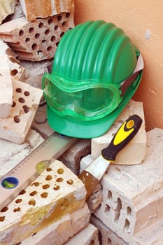 Bricks, trowel, level and helmet on work place 