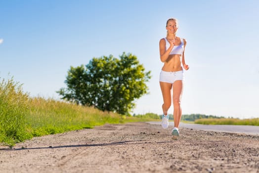 young athletic woman running on the road, exercise outdoors